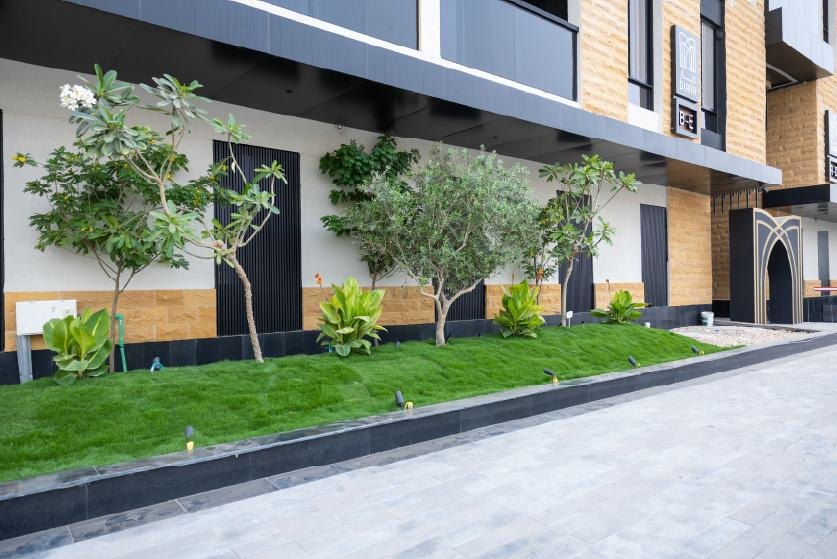 Trees and lawn along a building facade
